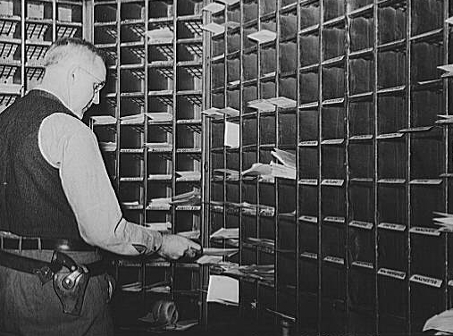 b&w Photo of American Post Office Mail Clerk Sorting Mail on a Train